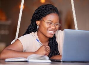 Happy african girl learning computer